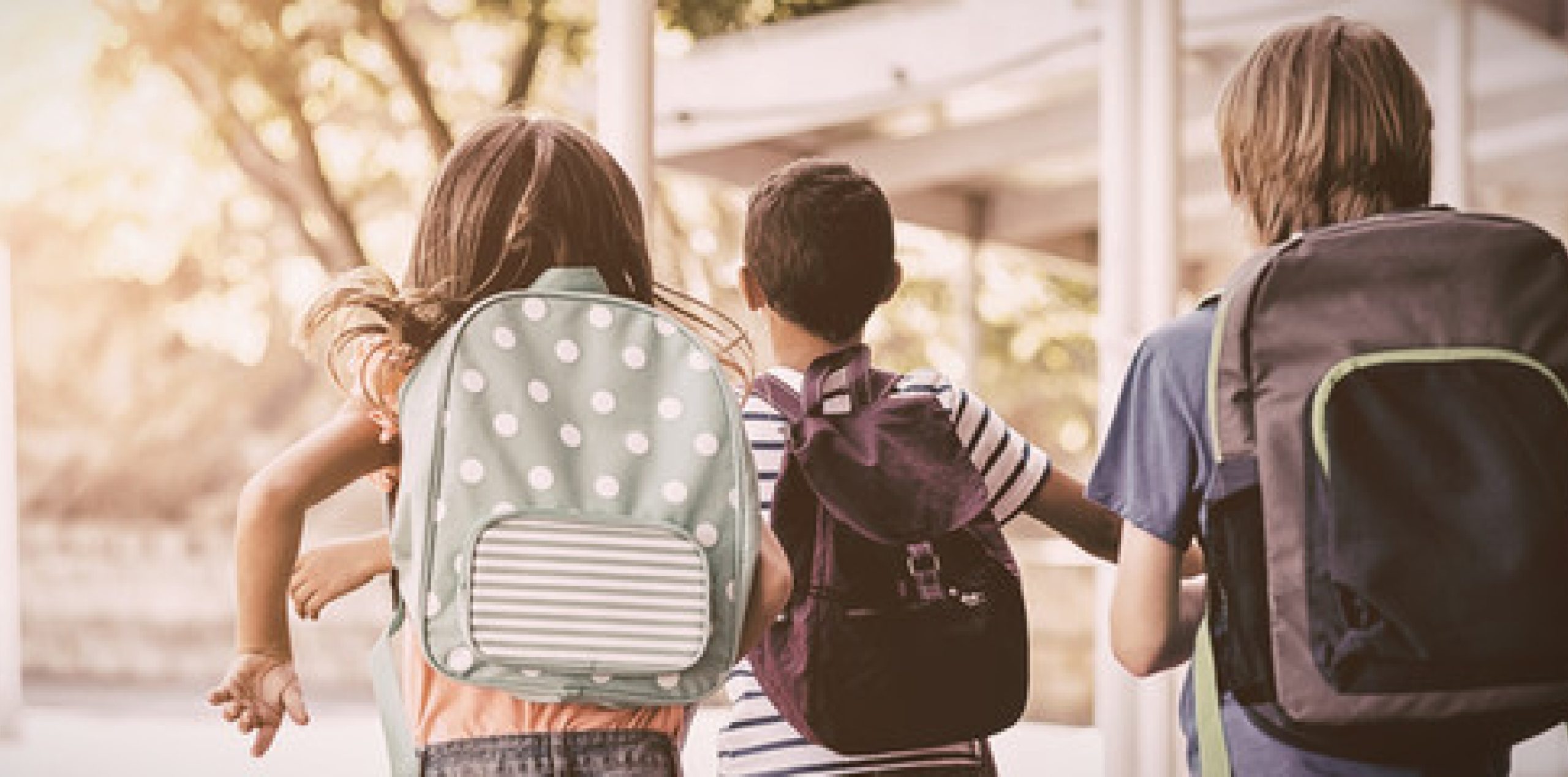 children wearing backpacks